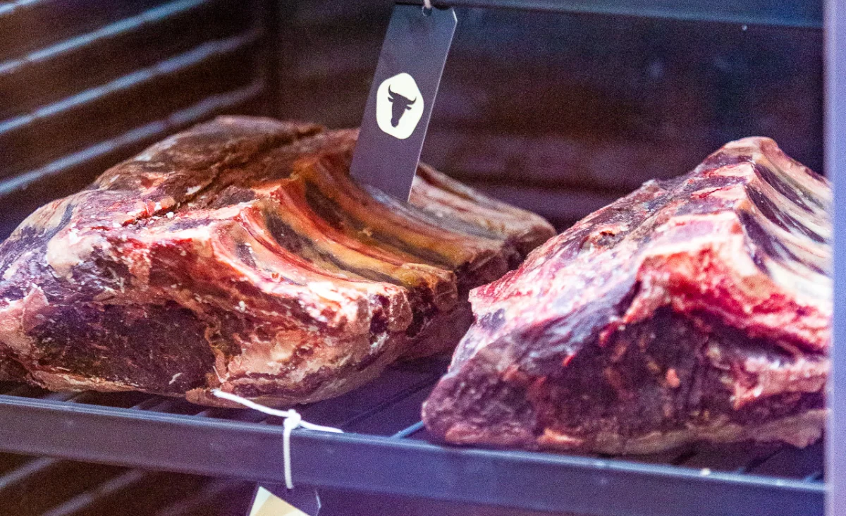 Zwei große Fleischstücke werden auf dem Grill im asiatischen Restaurant Zhou's Five im Ratskeller Reinickendorf zubereitet.