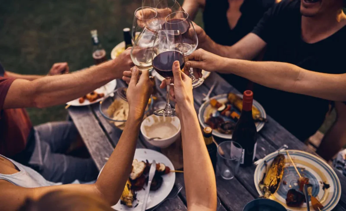 Mehrere Personen heben ihre Weingläser zum Anstoßen und genießen einen festlichen Moment zusammen. Vinoscout Kleinmachnow – Weinvielfalt im Flagshipstore.