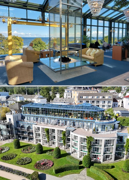 Luftaufnahme des Hotel Kaiserhof Heringsdorf mit Glasdach und gepflegtem Garten mit Blumenbeeten und Hecken sowie Innenraum mit Sitzgruppe und Meerblick durch große Fenster