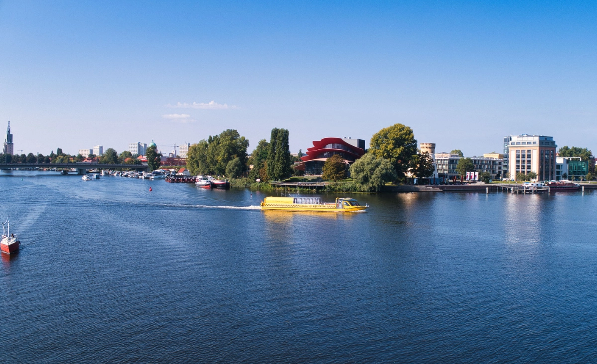 Wassertaxi auf dem Potsdamer Gewässer, umgeben von urbaner Landschaft und grünen Ufern.