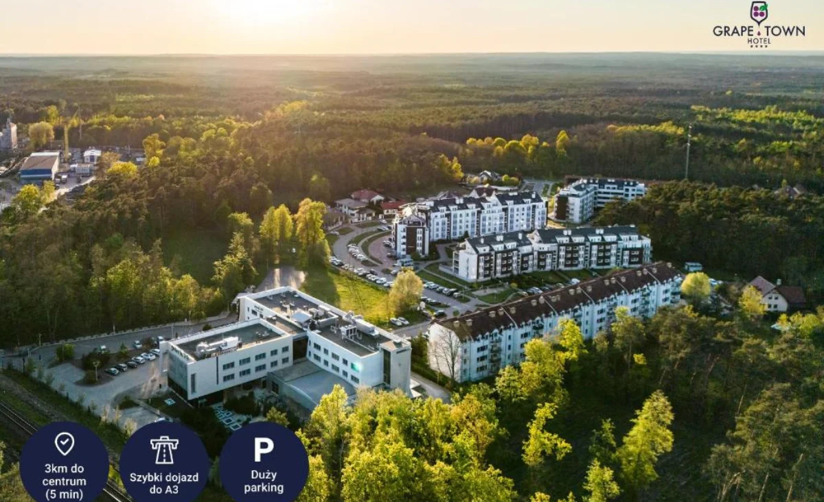 Luftaufnahme eines großen Apartmentkomplexes, Grape Town Hotel in Zielona Góra, umgeben von Grünflächen.