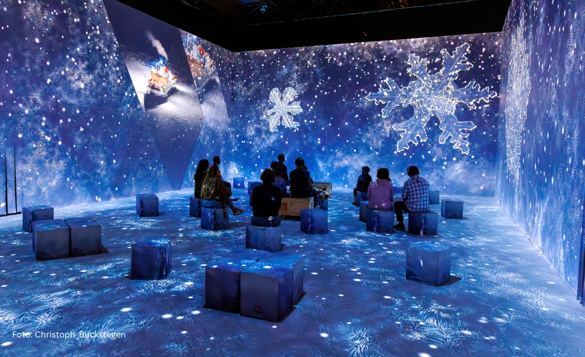 Projektionen von Schneeflocken und Sternen an Wänden und Boden der Immersive Ausstellung "Polar Experience"