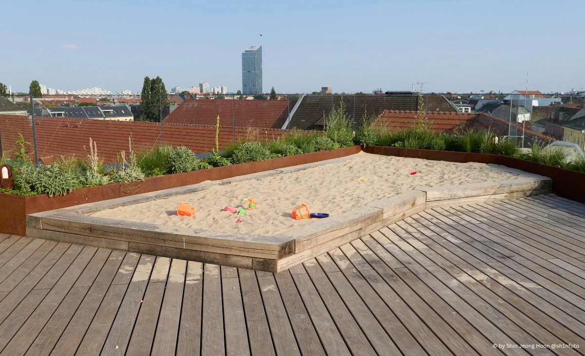 Ein Holzdeck, mit einem Sandkasten, ideal für Kinder zum Spielen und Entspannen.