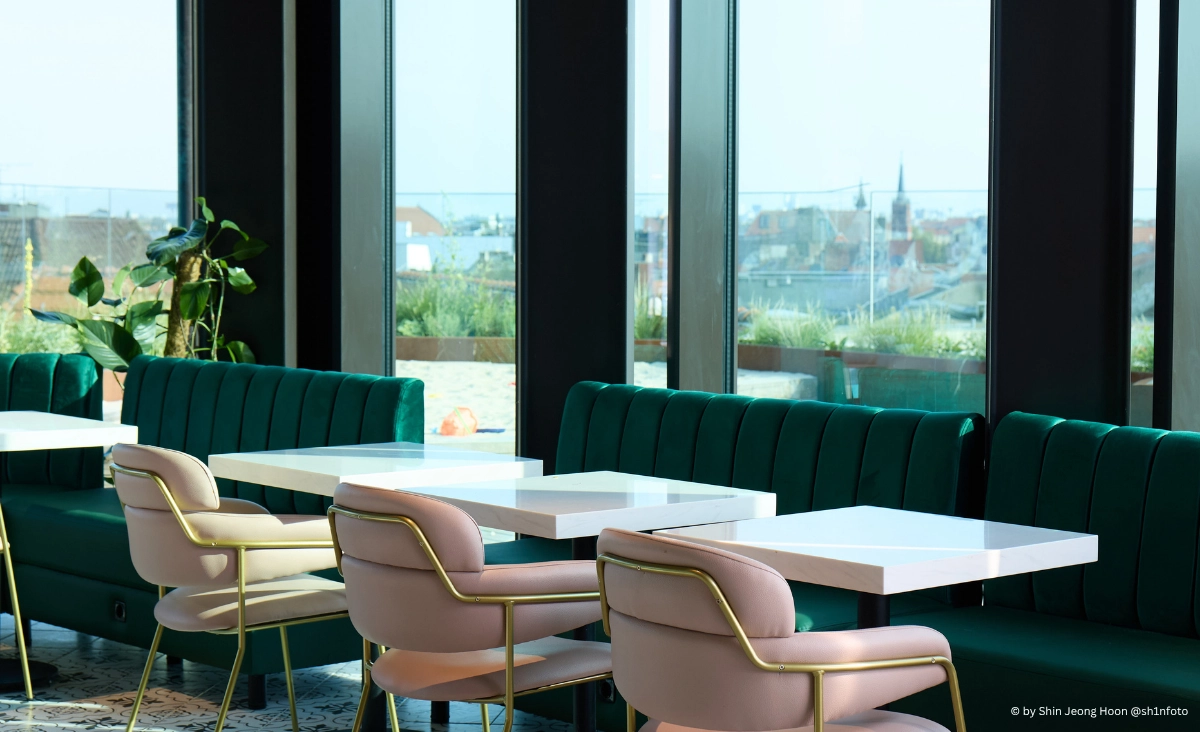 Restaurant "The Dawn Berlin" zeigt grüne Stühle und Tische, die eine freundliche und entspannte Umgebung schaffen.