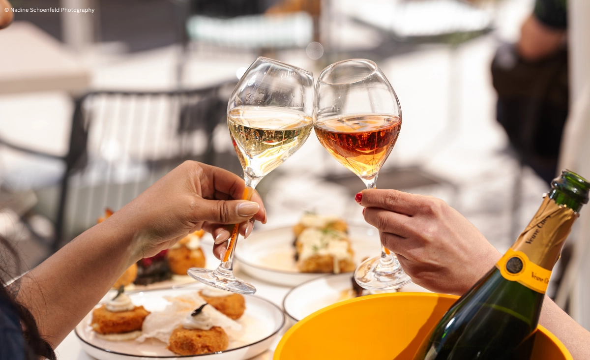 Zwei Personen stoßen mit Champagnergläsern an, um einen besonderen Moment zu feiern.